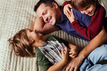 Two happy brothers  having fun with father at home. Funny sons and daddy