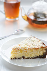 slice of a cheesecake with a cup of tea