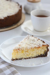 slice of a cheesecake with a cup of tea