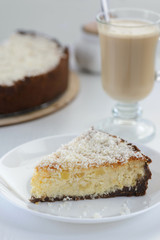 slice of a cheesecake with a cup of coffee on a cake background