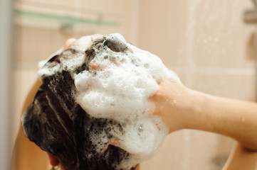 Beautiful naked young woman taking shower in bathroom