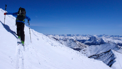 male backcountry skier going up a snow slope in the backcountry of the Swiss Alps on a ski tour in winter
