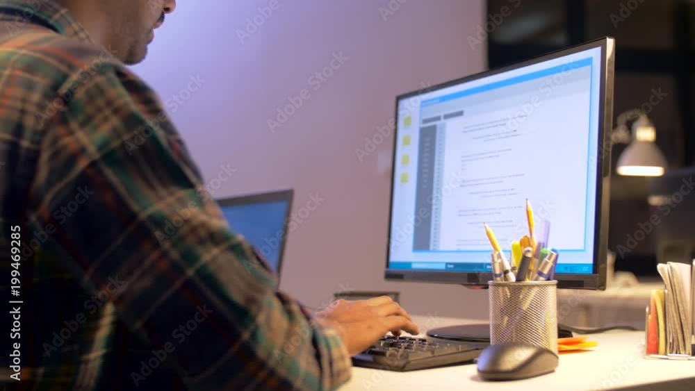 Poster deadline, technology and people concept - programmer with computer working together late at night of