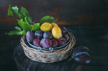 Ripe and juicy yellow and blue plums in a wicker basket in a rustic style. Happy Thanksgiving.