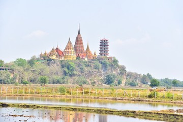 Scenic View of Wat Tham Sua with Rice Fields in Kanchanaburi Province