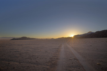 Fototapeta na wymiar Jeep tracks to the rising sun