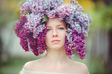 Outdoor fashion photo of a beautiful young blue-eyed woman. Spring color. beautiful blonde girl in lilac flowers. Perfume with a scent of flowers. Perfumes and beauty