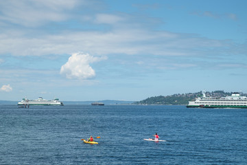 Obraz premium Ferry boats and paddleboarders