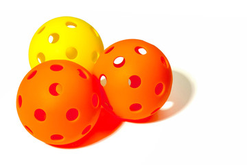 Three Pickleballs - 2 Orange and 1 Yellow together on a white background.