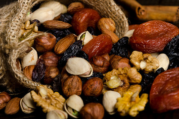 nuts, dried fruits, pistachios and other scattered from the bag on the table
