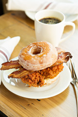 Hot spicy fried chicken and bacon sandwich in a donut