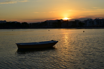 Naklejka na ściany i meble Zachód słońca nad wodą, łódka na pierwszym planie