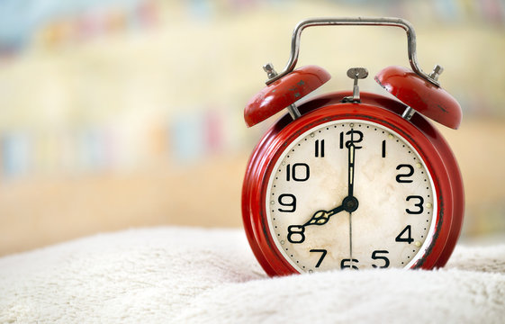 Good morning, wake up, awakening concept - retro red alarm clock in the bed - web banner with copy space