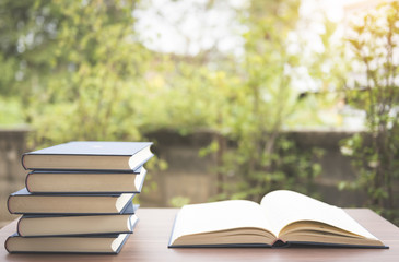 Opened book on wooden table on bright background