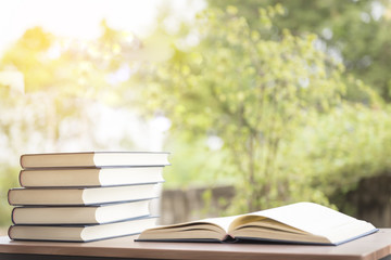 Opened book on wooden table on bright background