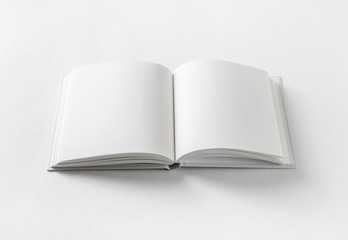 Blank open book on white paper background.