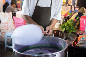 Hands of man spinning white cotton candy