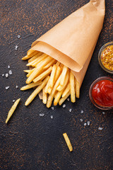 French fries in a paper bag with sauces