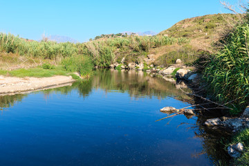 Small river flows into the sea on pebble beach