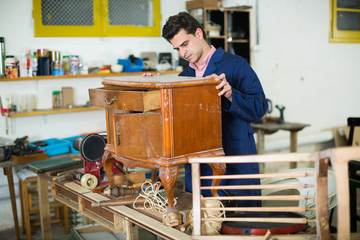 Obraz premium Restorer of furniture in workroom