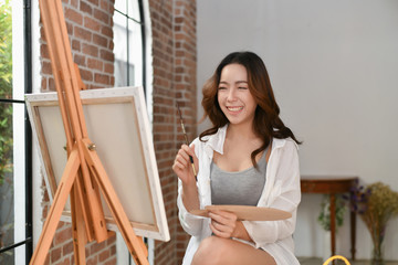 Concept Artist Beautiful girl. Beautiful women are creating art. Beautiful woman is painting happily. Young artist painting in the gallery.