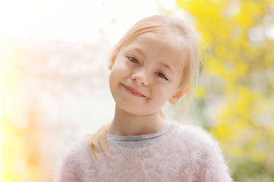 douce fillette blonde dans jardin au printemps
