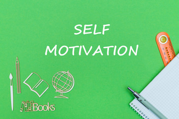 concept school, text self motivation, school supplies, notebook, ruler and pen on green backboard