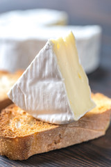 Toast with Camembert cheese on the wooden board