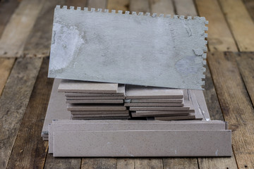 Laying and cutting tiles. Tools and building materials at a working position. Tiles for industrial and technical applications.