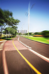 Hiking trail and bike lane surrounded by nature on a beautiful day at a park. Blurred movement effect.