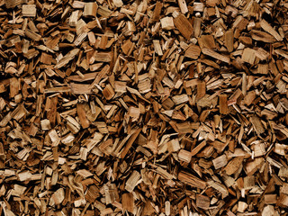 Dark brown wood chips create abstract rough-textured organic background surface