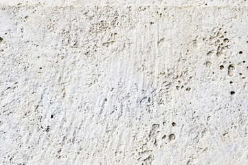 Close-up Deep texture of white-painted porous stone on the facade of the building. Stoned wall background texture