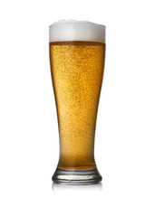 Freshly poured golden amber beer with frothy head and bubbles in a glass isolated on white