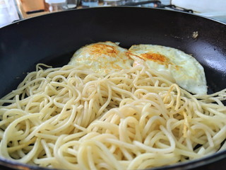 Spaghetti with fried eggs in a frying pan, home cooking, cooking, American cuisine, Italian cuisine, warm food, pasta, chicken eggs, simple food