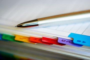 Selective focus alphabetical index address book with mechanical pencil.