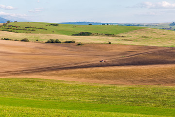 Fototapeta na wymiar Summer hills landscape with tractor in Slovakia.