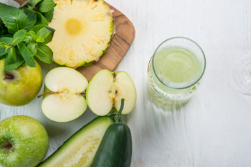 Top viev of glass juice made of cucumber, apple and pineapple