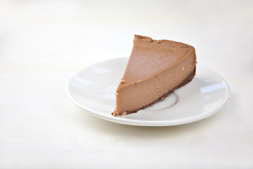 chocolate cheesecake on white plate on  wooden table