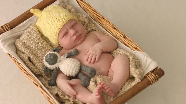 Portrait of falling asleep two-week old baby in a cradle
