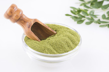 Moringa leaves and powder on white background