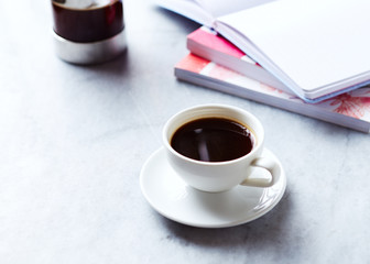 Cup of Black Coffee, books and coffee press on gray marble background