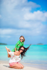 Fototapeta na wymiar Beautiful mother and daughter at Caribbean beach enjoying summer vacation.