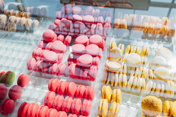 Assortment of colorful macaroons on cafe showcase. Variety of macaron flavours. Sweet almond cakes in store.