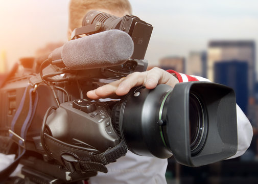 Video operator with camcorders on tripods recording video at an event