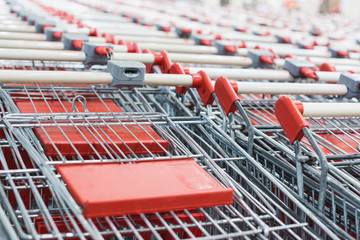 Red shopping cart. Trolley pattern in front of a supermarket, ready for customers to use.