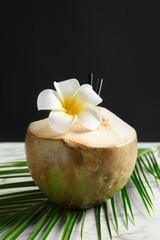 Obraz na płótnie Canvas Fresh green coconut on table against dark background