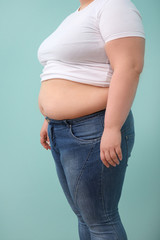 Overweight woman on color background