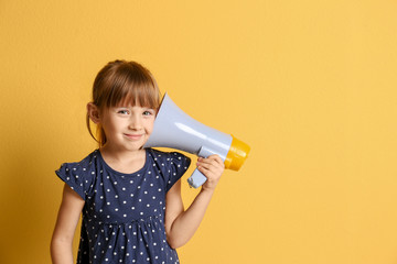 Cute little girl with megaphone on color background