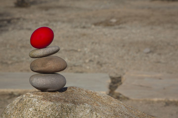 Fototapeta na wymiar Conceptual financial risk background with red egg on stacked rocks