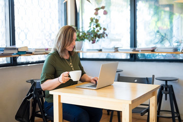 Hispanic businesswoman busy working at cafe